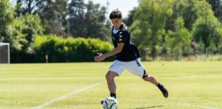 System szkolenia młodzieży w klubach Premier League i jego wpływ na reprezentację Anglii Nastolatek prowadzący piłkę na trawiastym boisku w słoneczny dzień