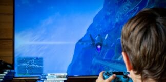 Najlepsze gry z otwartym światem na PC i konsole: przewodnik dla początkujących i zaawansowanych graczy Chłopiec grający na konsoli PS4 przed telewizorem w domowym salonie