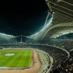 Zapełniony stadion piłkarski oświetlony nocą podczas meczu