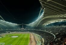 Zapełniony stadion piłkarski oświetlony nocą podczas meczu