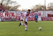 Piłkarz w akcji podczas meczu na lokalnym stadionie