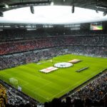 Kibice oglądający mecz piłki nożnej na wypełnionym stadionie